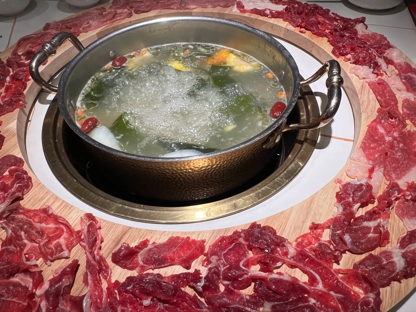 潮汕牛肉鍋 — 澄んだスープの鍋を新鮮な薄切り牛肉の大皿が囲む