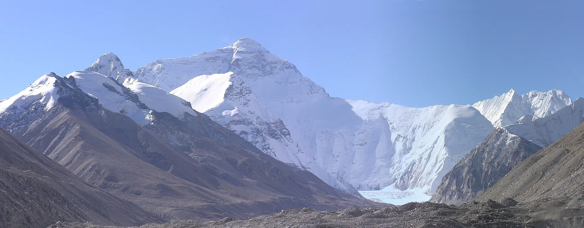 The north face of Mount Everest seen from the Tibet-side Base Camp, snow-covered against a clear blue sky