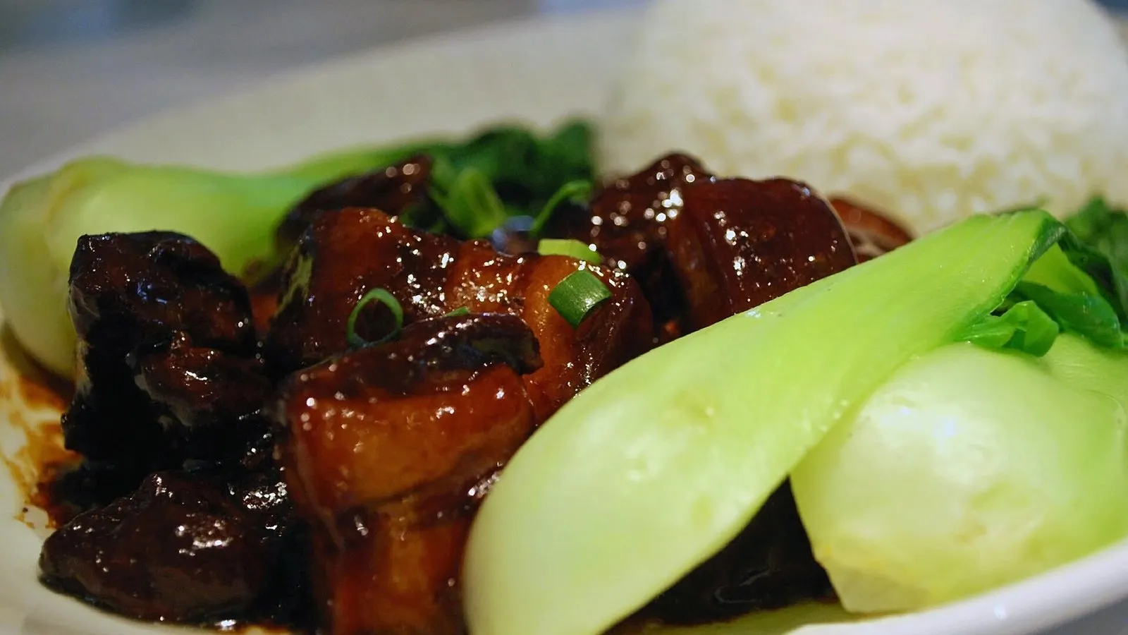 A plate of glossy hong shao rou, red-braised pork belly