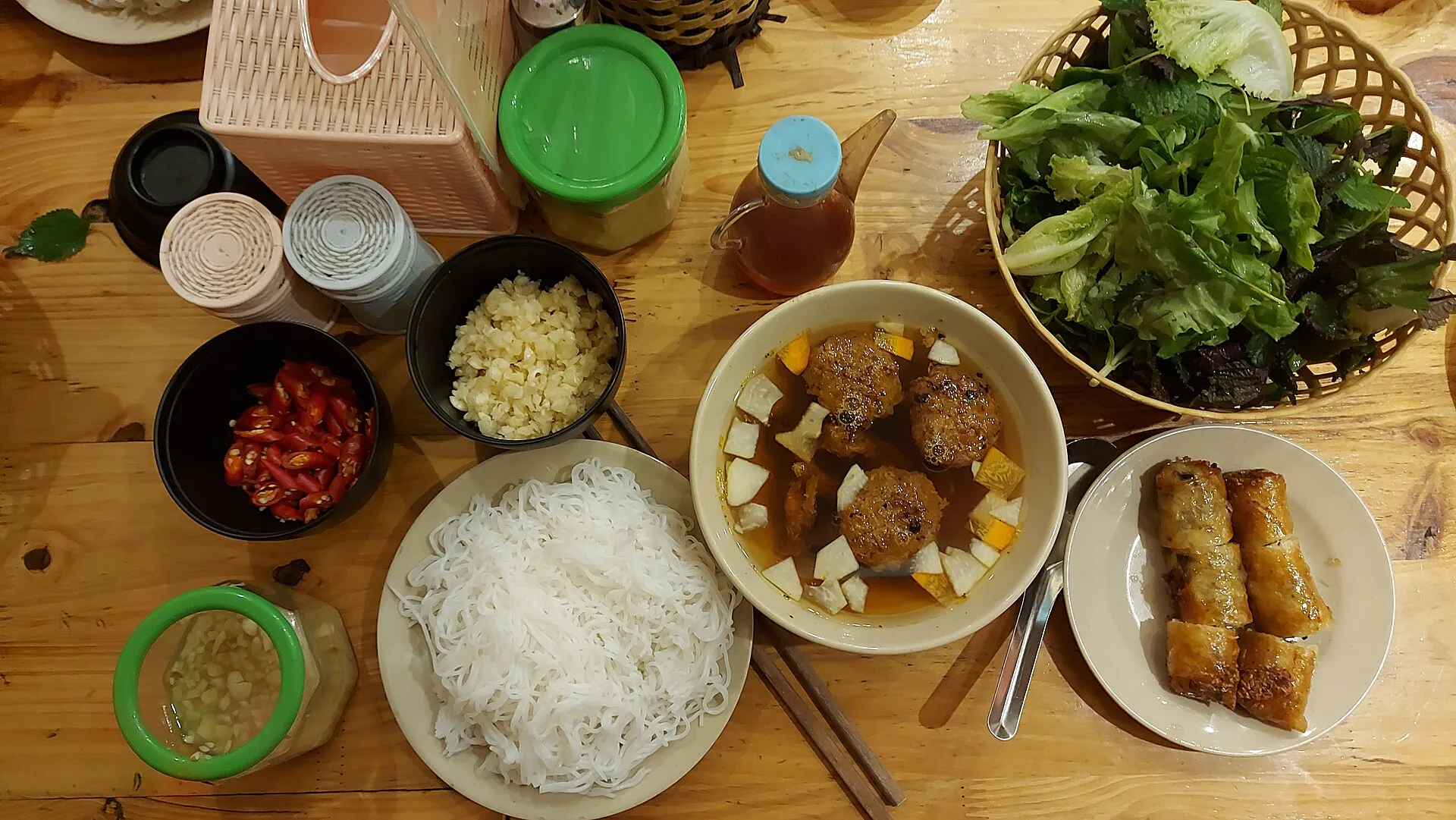 A classic Hanoi bun cha — grilled pork in fish-sauce broth with rice vermicelli, herbs and spring rolls