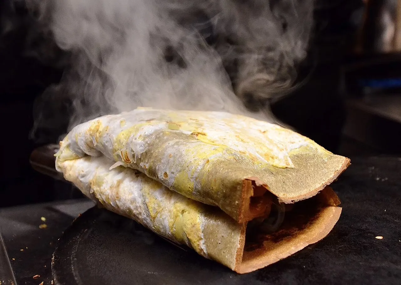 A jianbing being folded fresh on the griddle