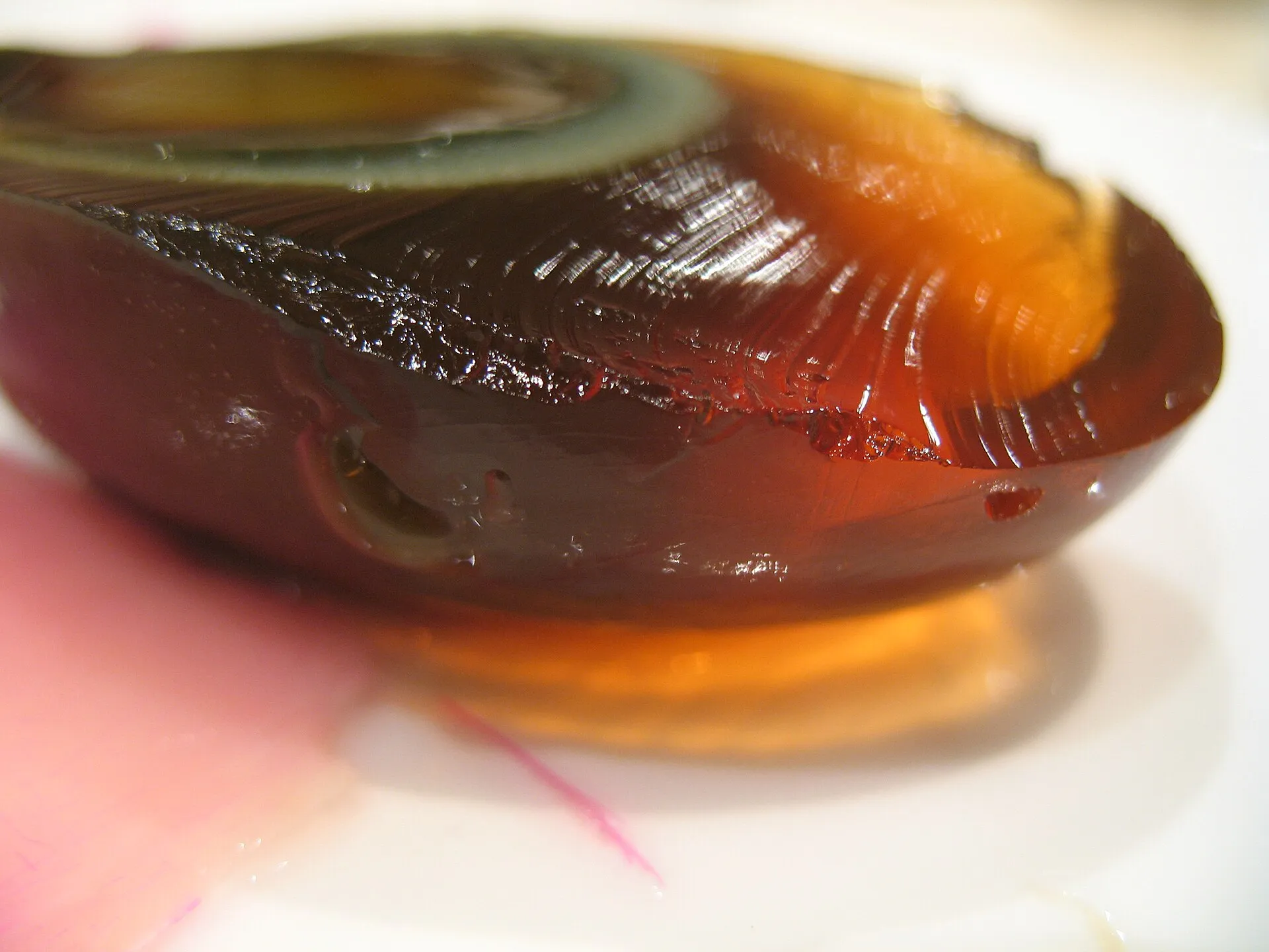 A halved century egg showing the translucent dark "white" and green-grey yolk
